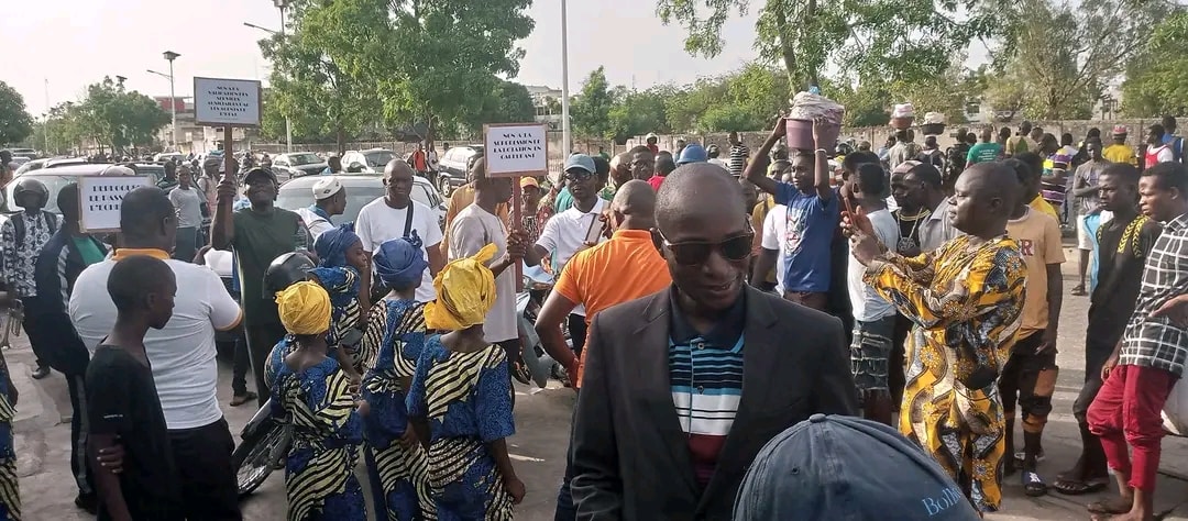Des manifestants tiennent des pancartes lors de la marche dispersée contre la cherté de la vie